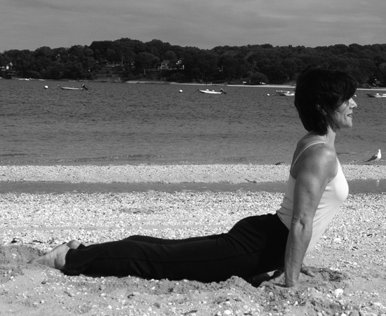 Endna Gruvman doing upward dog yoga pose on Long Island beach